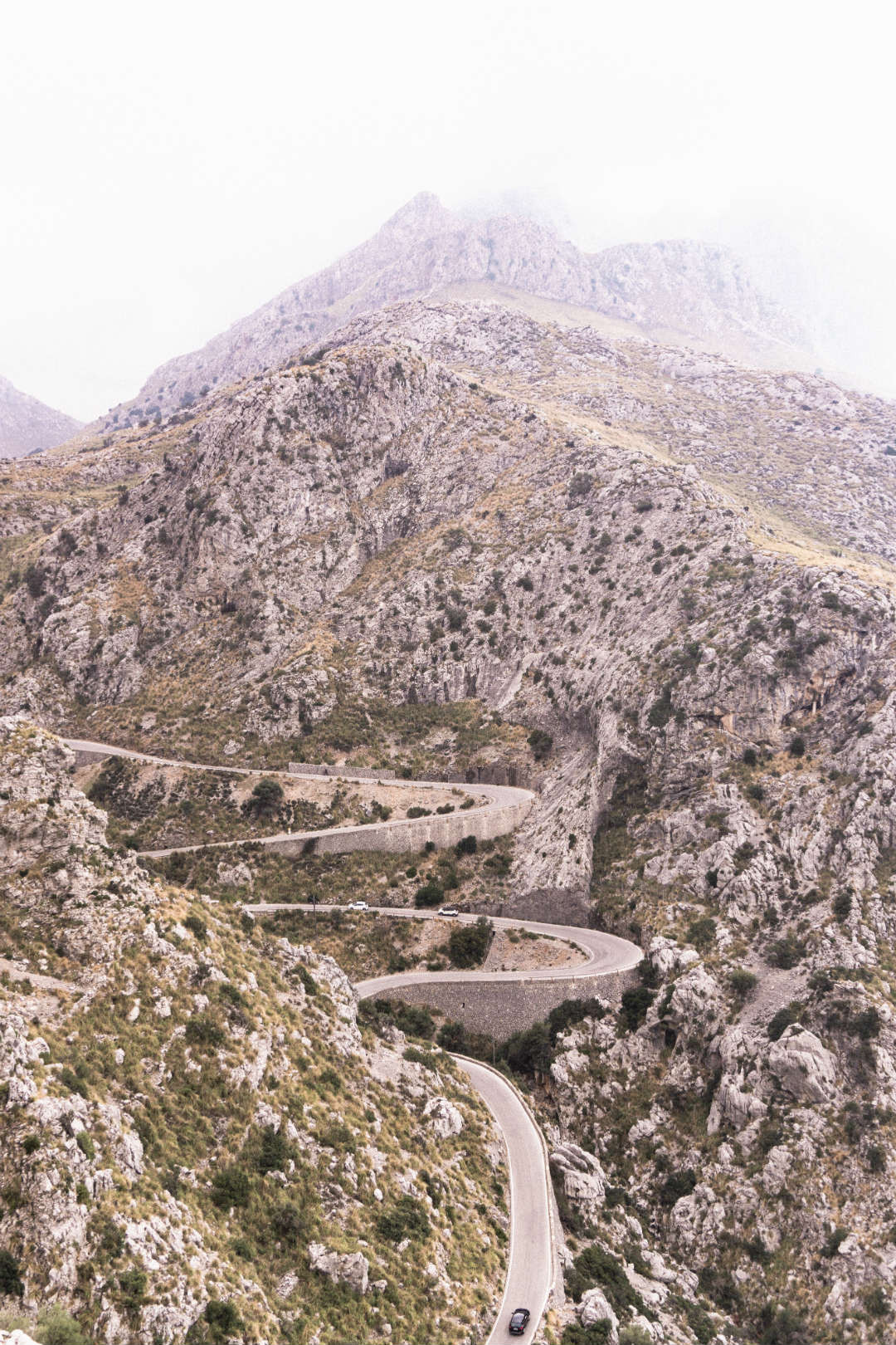 A close up of the road and switchbacks winding through the mountains that you'll experience on your road trip to sa calobra in Mallorca